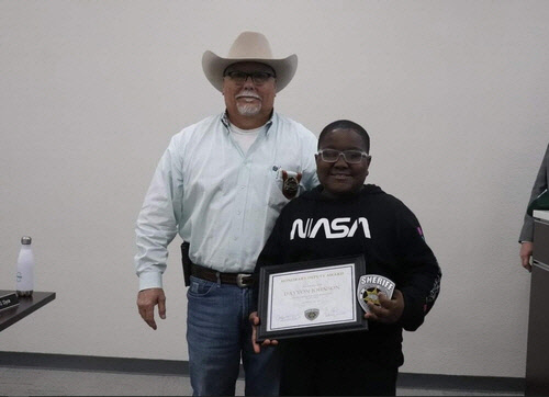 데이비언 존슨(오른쪽)이 지난 15일 머스코지 카운티 보안관으로부터 명예 부대원 임명장을 받고 기념촬영을 하고 있다. [머스코지 카운티 보안관 사무실 페이스북 캡처]